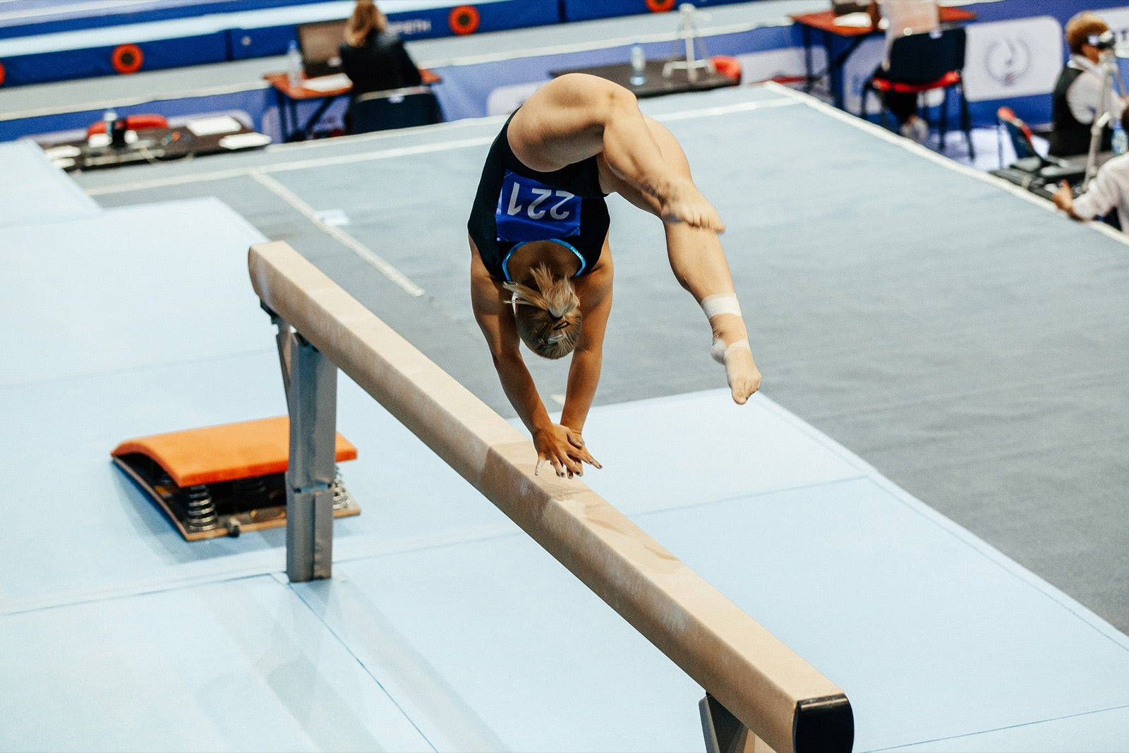 A gymnast performing on a balance beam during competition