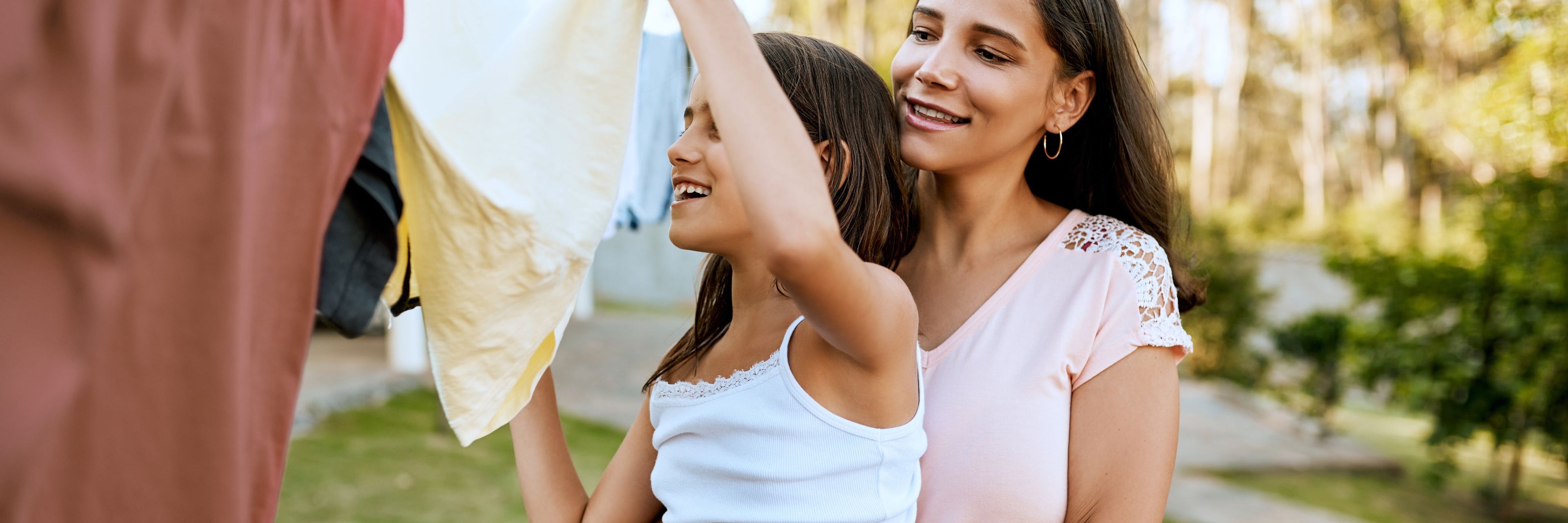 Mother and daughter hanging clothes together