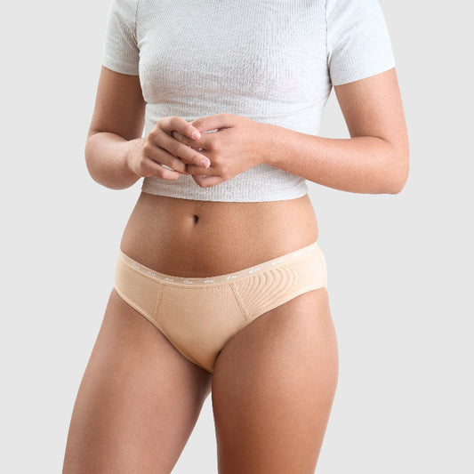 Girl standing in studio wearing grey top and Neutral coloured Eltee Sydney Bumpers Briefs period underwear