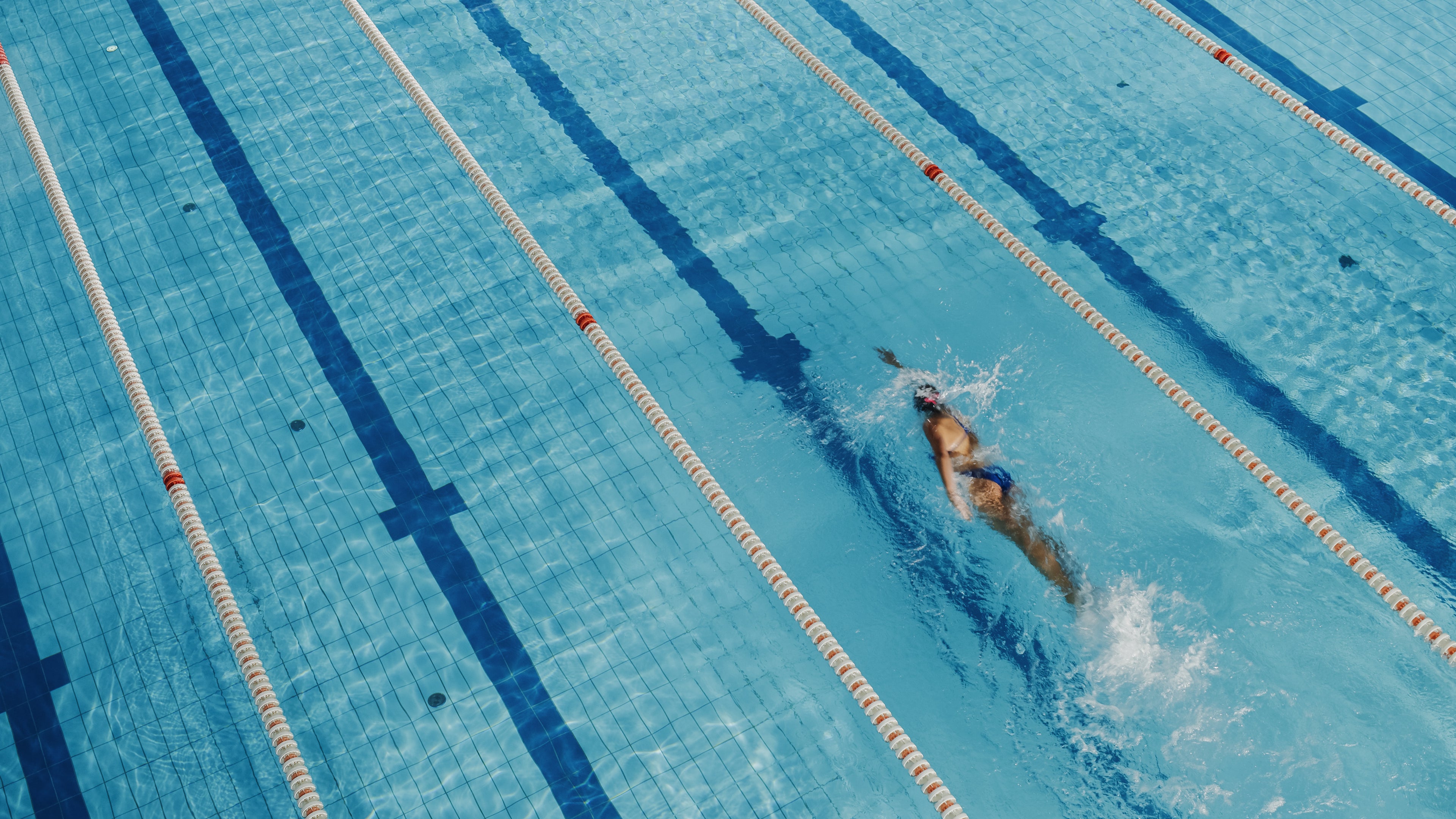 girl in swimming race suit in pool doing laps